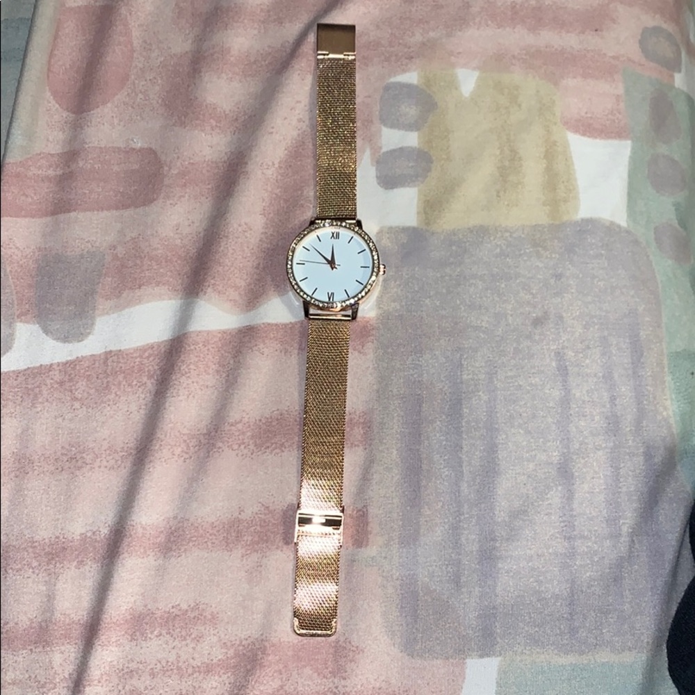 Gold colored watch with stones around the clock